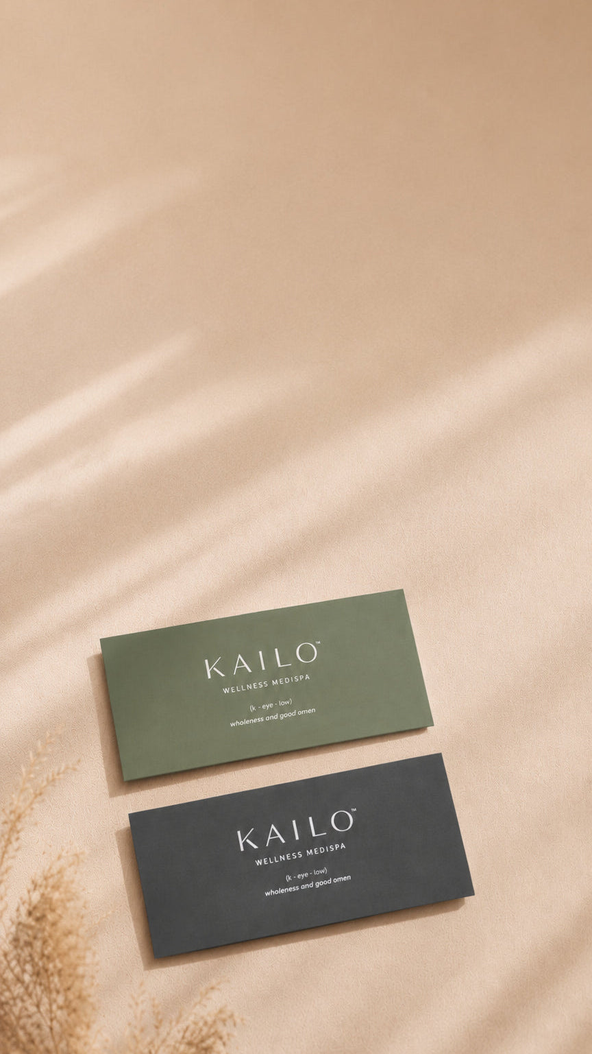 Two Kailo business cards on a beige surface with soft lighting.